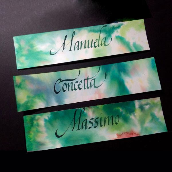 Tre cartoncini con sfumature di verde in varie tonalità e i nomi Manuela, Concetta e Massimo scritti in calligrafia